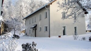 A two-story building with a sloped roof, surrounded by snow-covered trees. - Dom na Skraju by Interhome (Lubomierz/Gryfow Slaski)