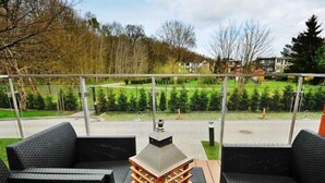 Un balcon agrémenté de meubles en osier et d’une pile de caisses en bois.