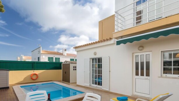 A rooftop pool area with a table set for dining, lounge chairs, and a lifebuoy. - Grand Beach Hit by Interhome (Pêra)