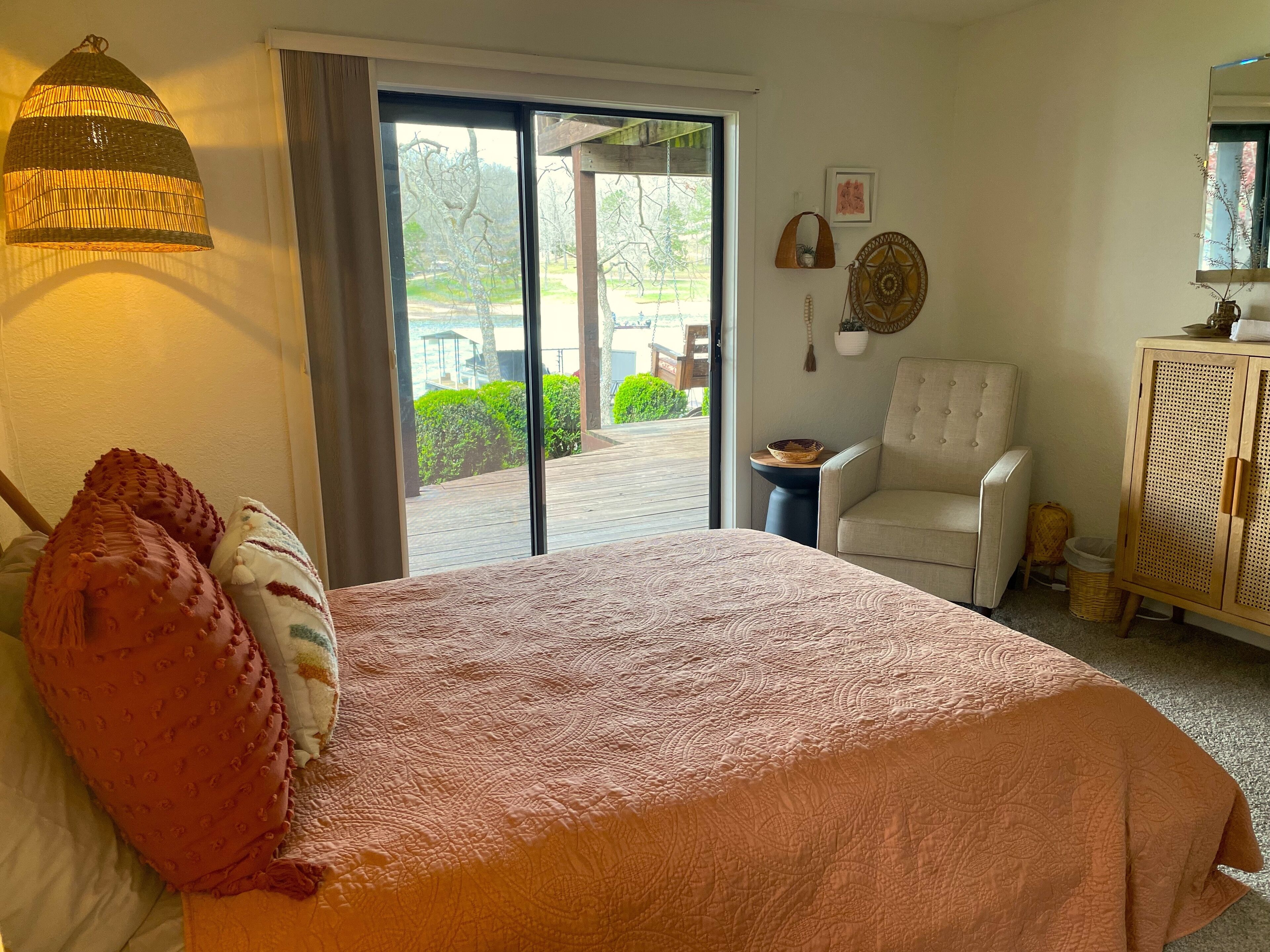Ein Schlafzimmer mit Bett, Stuhl, Schrank und Blick ins Freie.