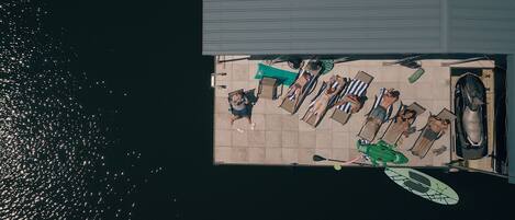 Vista aérea de una azotea con piscina, sillas de descanso y un kayak.