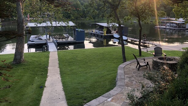 Une propriété au bord du lac, dotée d’un quai, d’un espace extérieur aménagé pour s’asseoir et d’un foyer en pierre.