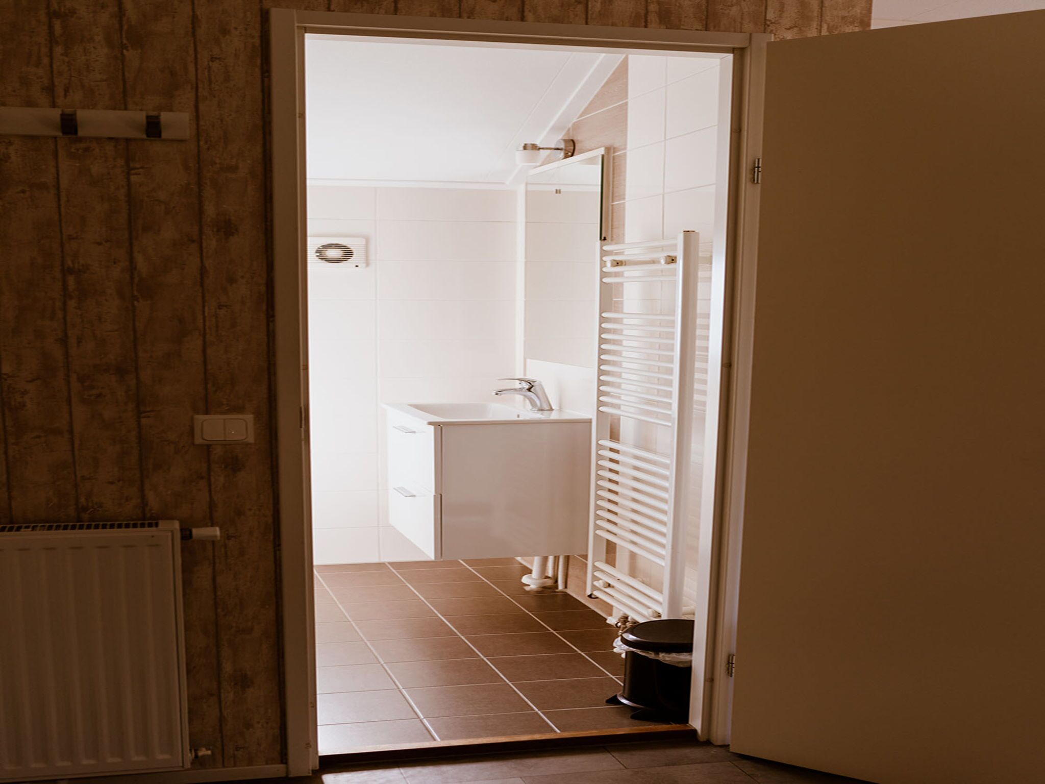 Un bagno con piastrelle bianche, un lavandino e un water.