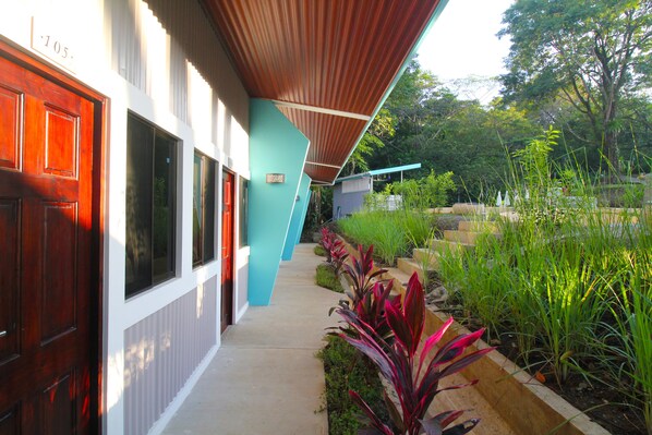 A building with a red door, a blue wall, and a covered walkway. - Téva Eco Retreat - Hostel (Quepos)