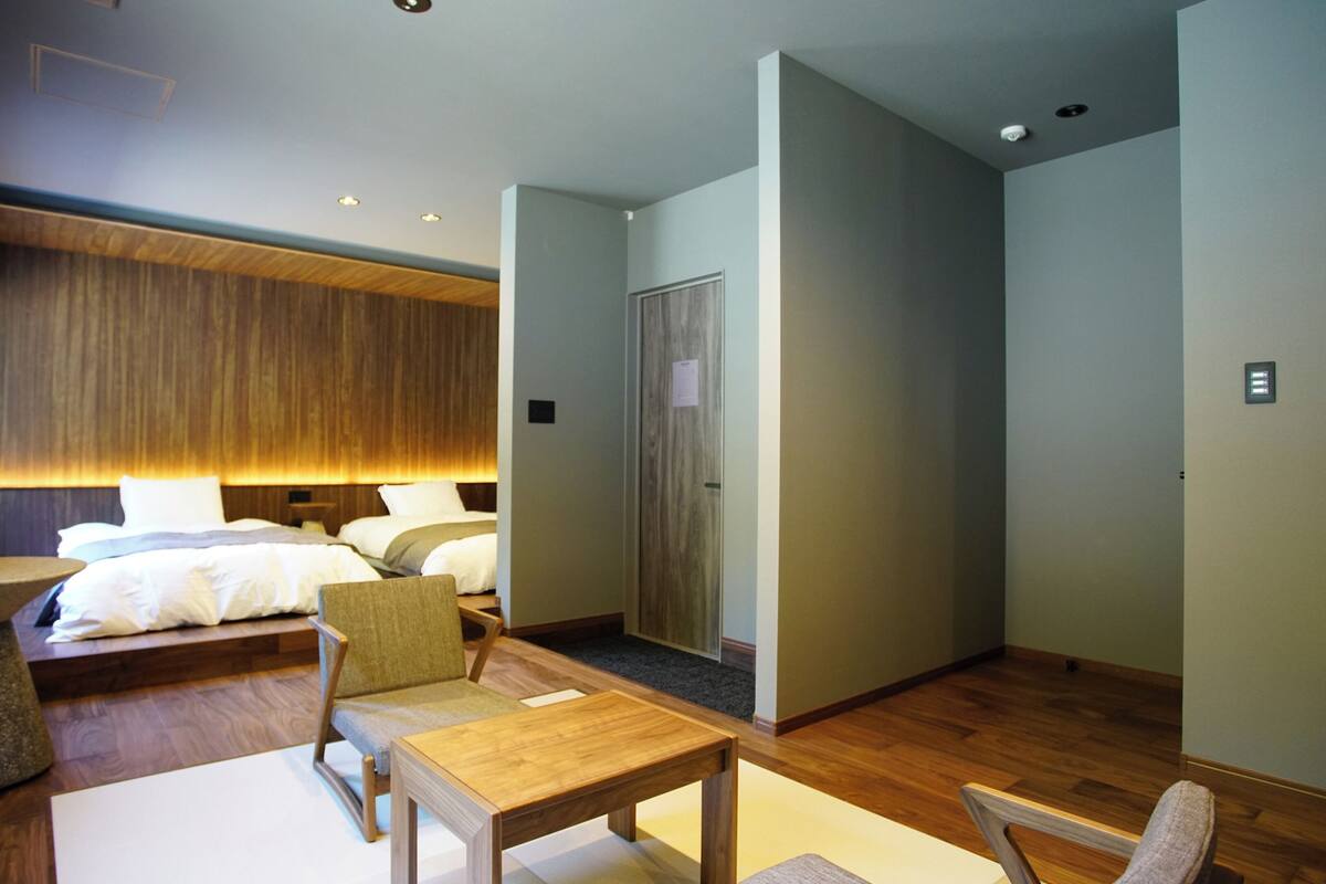 Una camera d'albergo moderna con un letto grande, una scrivania, una sedia e un tavolino.