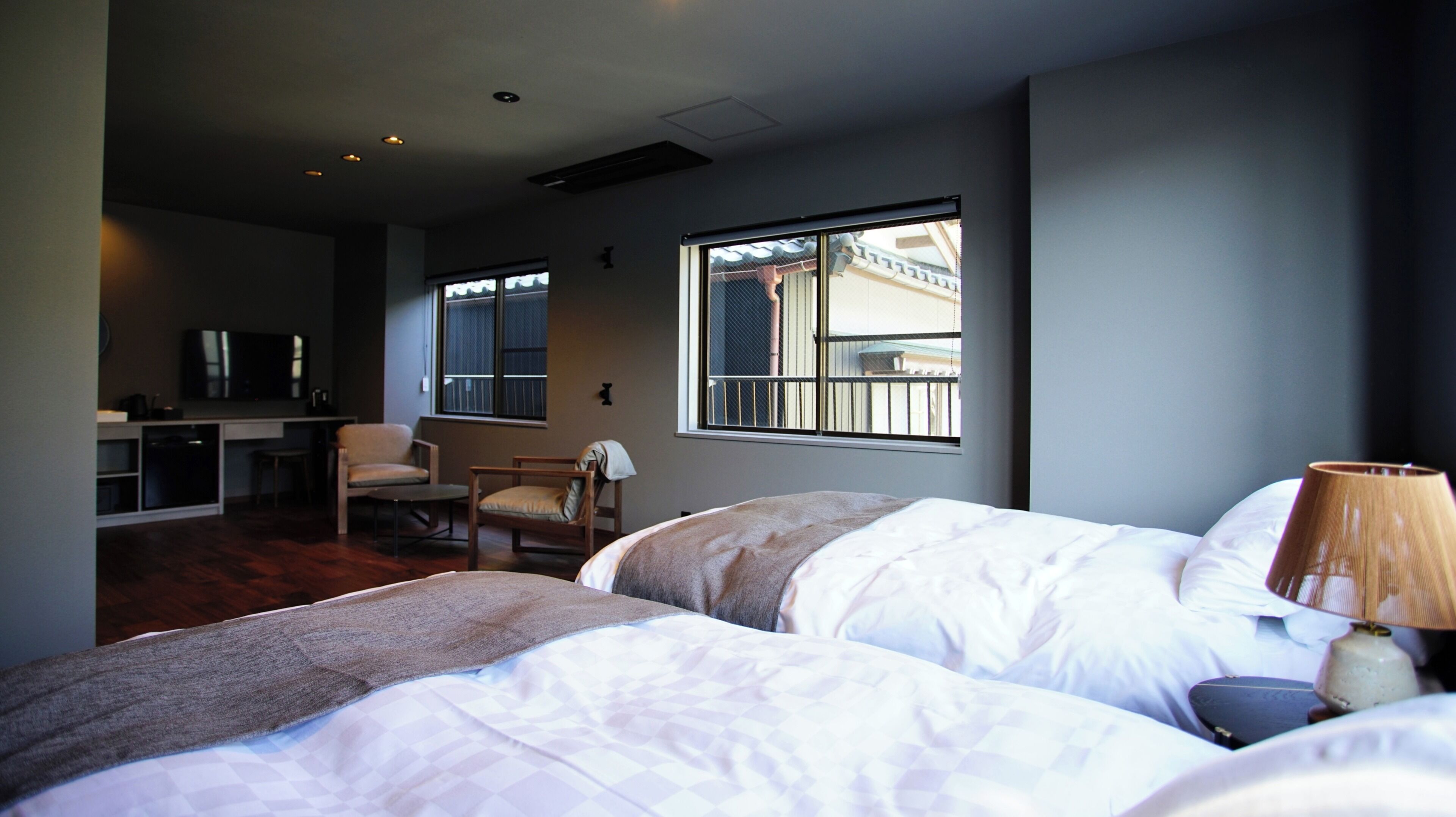 Ein Hotelzimmer mit zwei Betten, einem Schreibtisch, einem Stuhl und einem Fenster mit Blick.