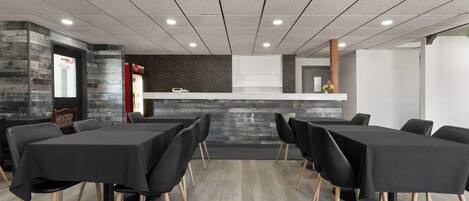 Un salón de conferencias con mesas y sillas, una mesa de recepción y un diseño interior moderno.