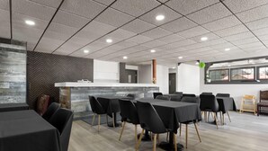 A modern conference room with a long table, black chairs, and a white reception desk. - Travelodge by Wyndham Blairmore (Blairmore)