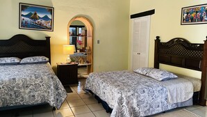 A room with two beds, a nightstand, a mirror, and a door. - Jabel Tinamit Hotel & Villas (Panajachel)