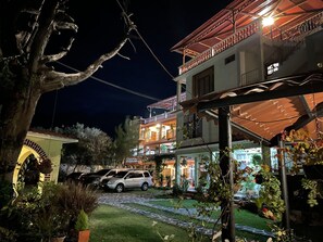 Un edificio de dos pisos con balcón y un patio cubierto.