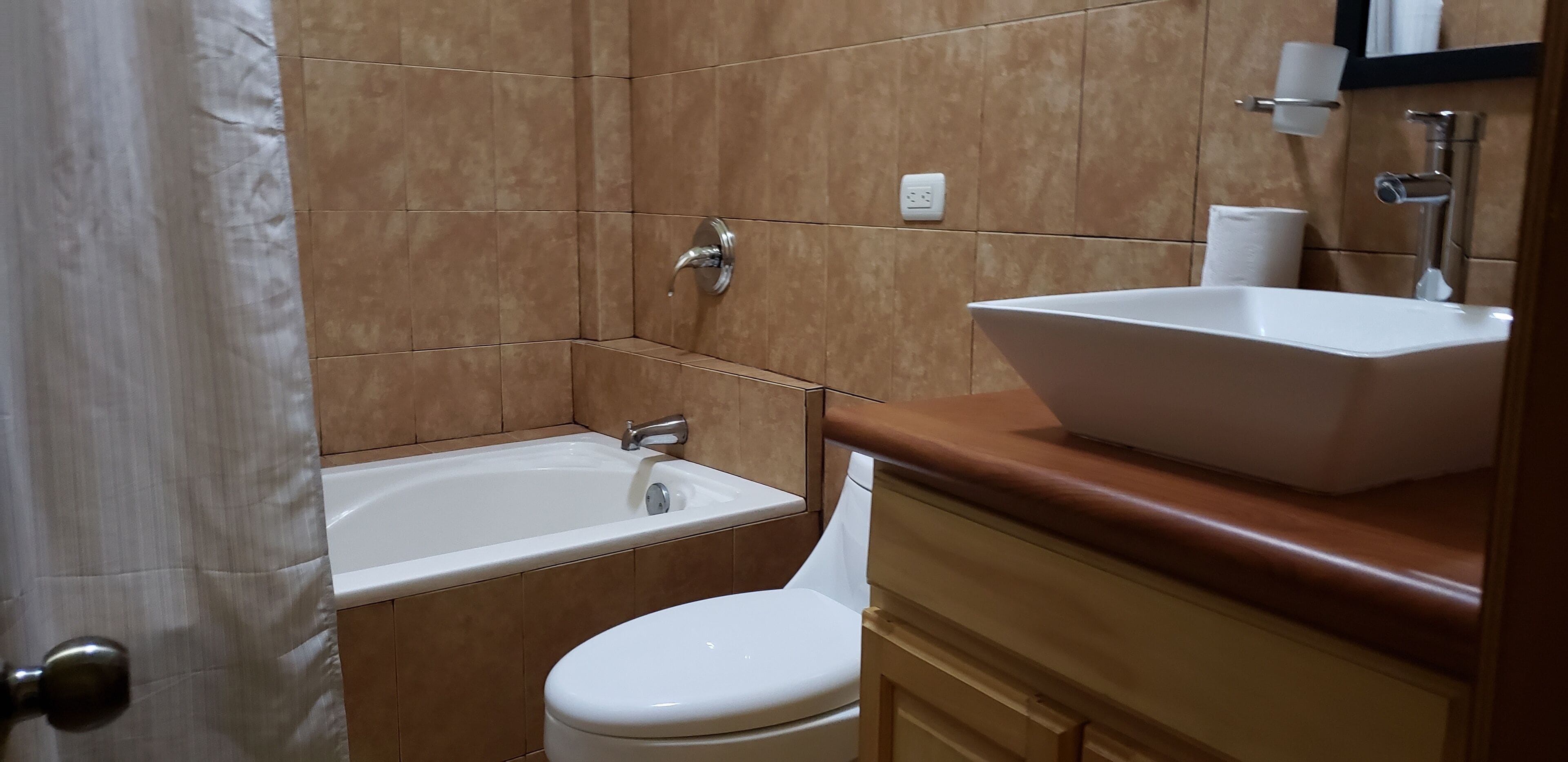 Un baño con bañera, inodoro y lavamanos.
