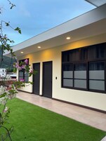 Un edificio moderno con techo plano, amplias ventanas y un césped cuidado.