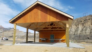 Una estructura de madera con techo inclinado, una puerta y una pequeña zona de cocina.
