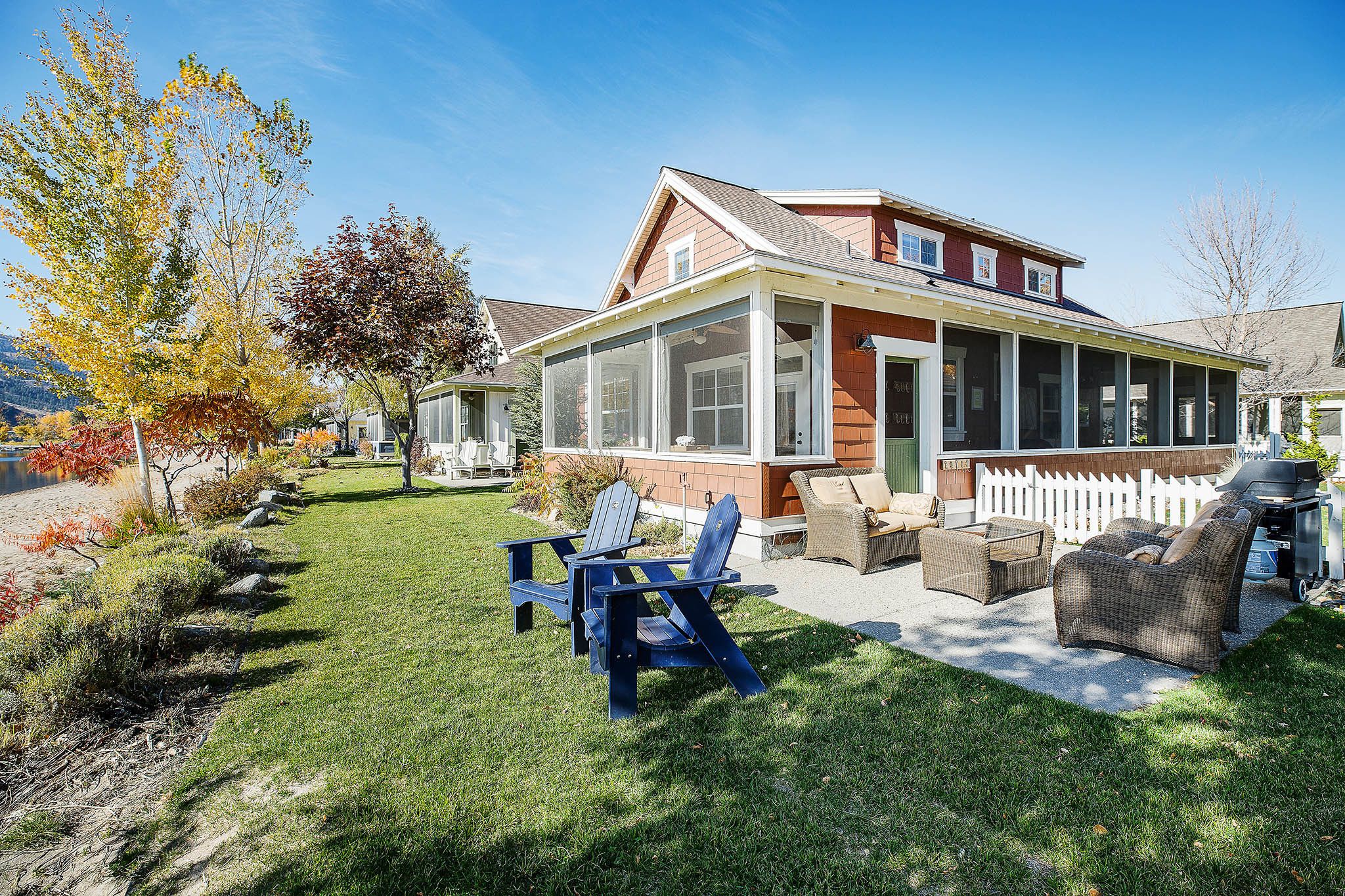 A house with a covered patio, a lawn, and outdoor furniture.