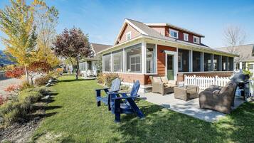 A house with a covered patio, a lawn, and outdoor furniture.
