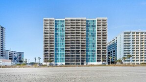 A high-rise hotel with multiple floors, balconies, and a clear view of the surrounding area. - Direct Oceanfront Condo Renovated & New Furniture-Pools,Hot Tub, Sauna,Free wifi (Myrtle Beach)