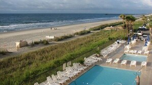 A beach resort with a swimming pool, lounge chairs, and a view of the ocean. - Direct Oceanfront Condo Renovated & New Furniture-Pools,Hot Tub, Sauna,Free wifi (Myrtle Beach)