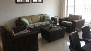 A living room with a sofa, two armchairs, a coffee table, and two wall-mounted mirrors. - Villa Ensueño - House with Pool & Hot Tub (Flandes)