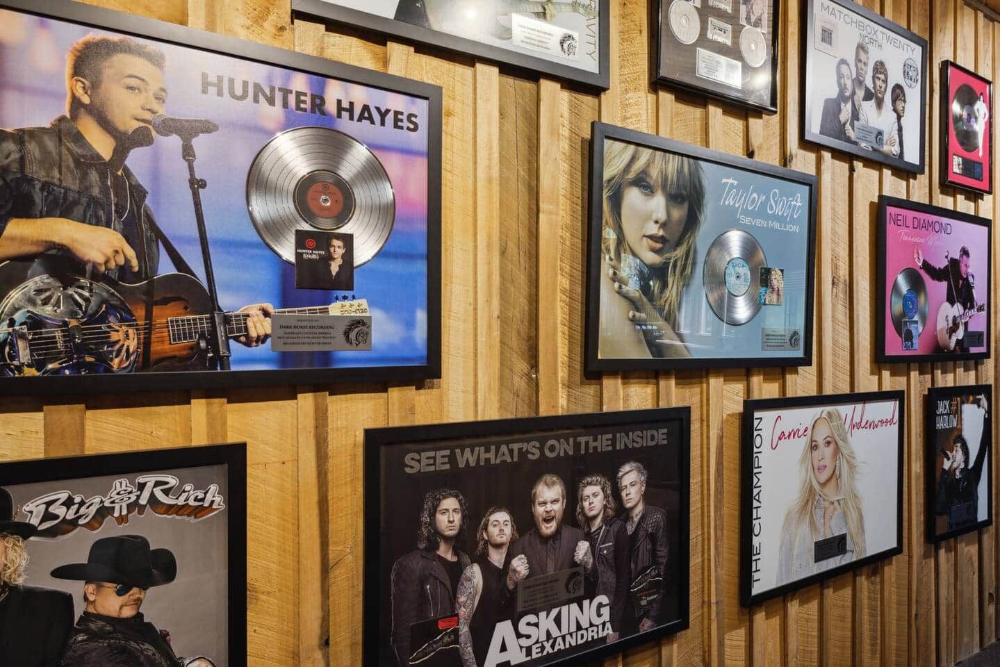 Eine Wand mit gerahmten Albumcovern und Auszeichnungen.