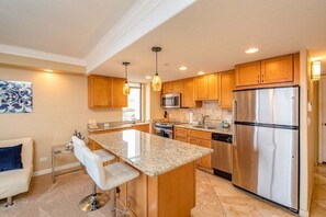 A modern kitchen with granite countertops, stainless steel appliances, and wooden cabinets.