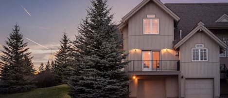 A two-story house with a garage, a balcony, and a driveway.