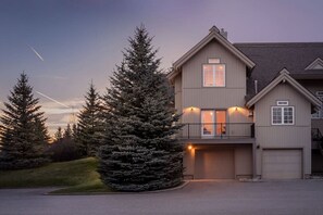 Une maison à deux étages avec un garage, un balcon et une allée.