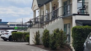 A two-story building with a balcony and a staircase leading to the upper floor. - Great Lake Motel Taupo (Taupo)