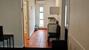 A narrow hallway leading to a kitchen area with a sink, a chair, and a small table. - Great Lake Motel Taupo (Taupo)