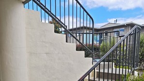 A concrete staircase with black railings leading to a second-floor landing. - Great Lake Motel Taupo (Taupo)