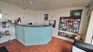 A reception area with a counter, informational posters, and a bulletin board. - Great Lake Motel Taupo (Taupo)