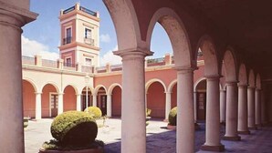 An architectural structure with a central courtyard, featuring a tower and multiple arches. - Casa del Árbol Hostel (Concepción del Uruguay)