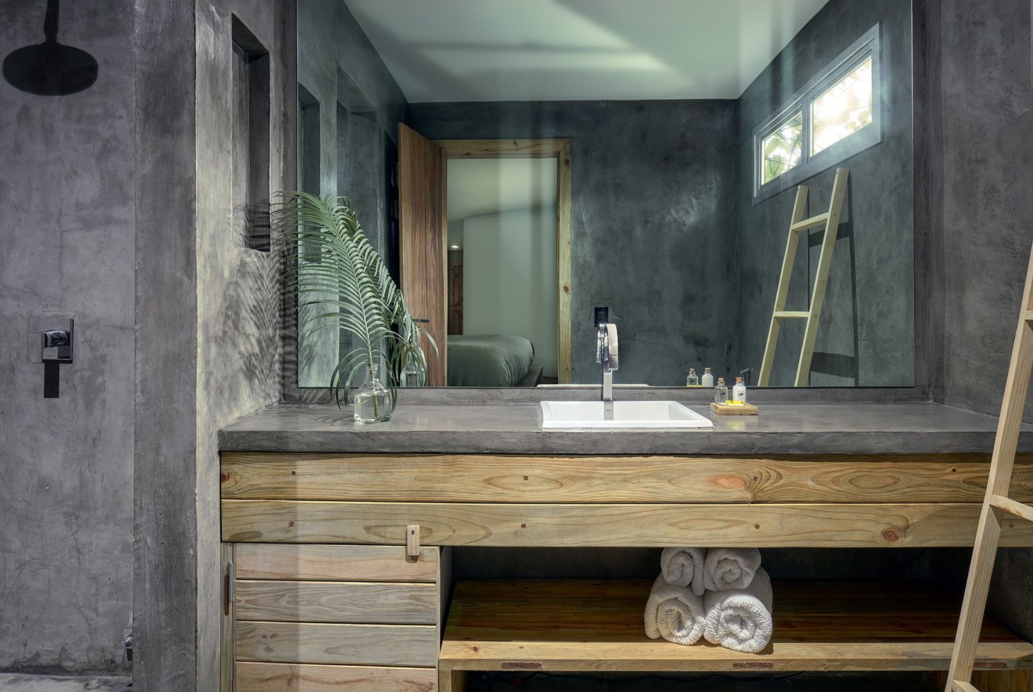 Een moderne badkamer met een grote spiegel, een houten wastafelmeubel, een wastafel en een handdoekrek.