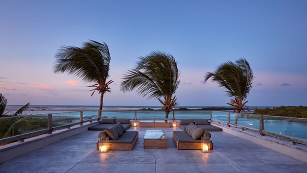 A rooftop lounge with a pool, palm trees, and a sunset view. - Casa Uca (Camocim)