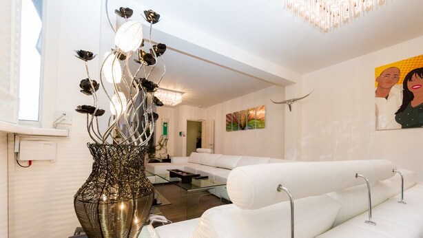 A modern living room with a white sofa, a glass coffee table, and a decorative metal vase. - 5* Luxury Spacious Apartment (Mitcham)