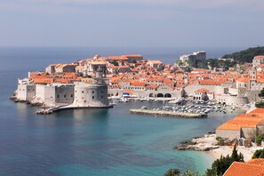 Eine Küstenstadt mit historischen Gebäuden, einer Festungsanlage und einem Yachthafen.