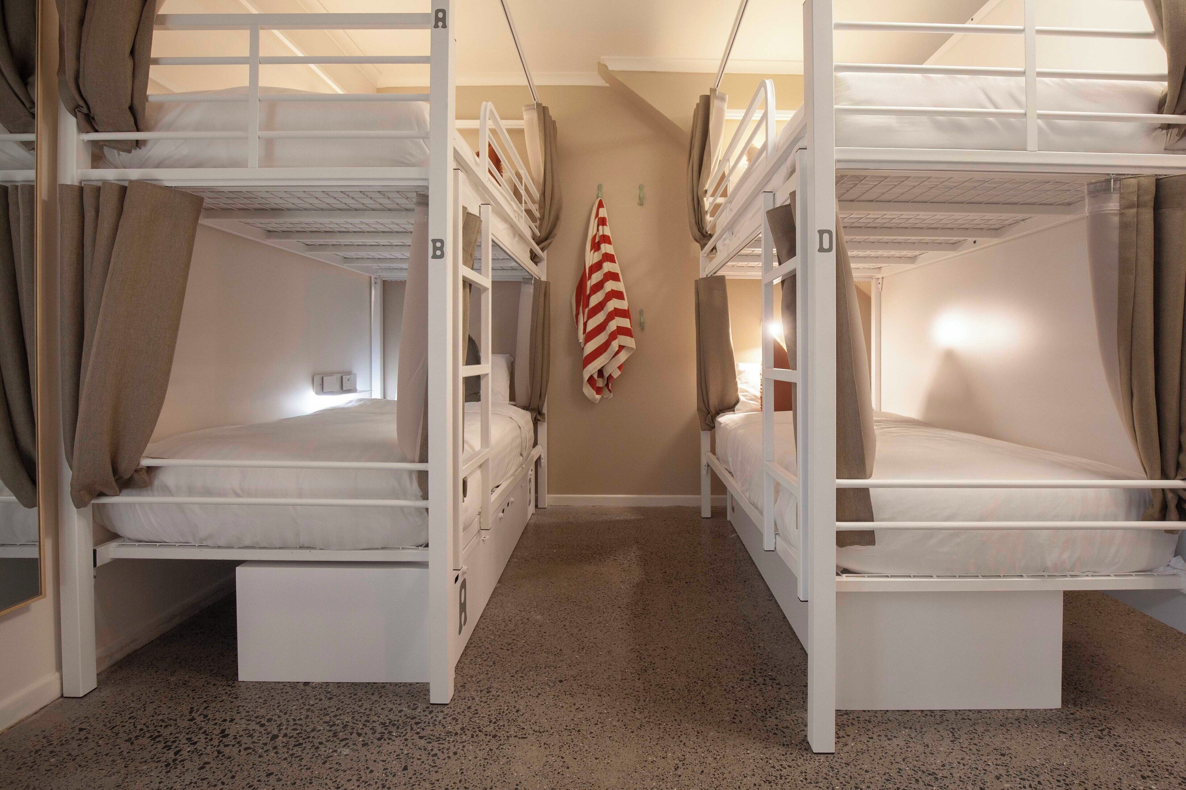 A bunk room with two beds, a small desk, and a flag on the wall.