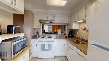 Condo tradicional, varias camas, vista parcial al océano | Cocina privada