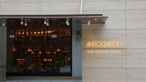 The exterior of The Mumin Hotel with a modern design, featuring a large glass entrance and illuminated signage. - The Mumian Hotel Shenzhen Houhai (Shenzhen)