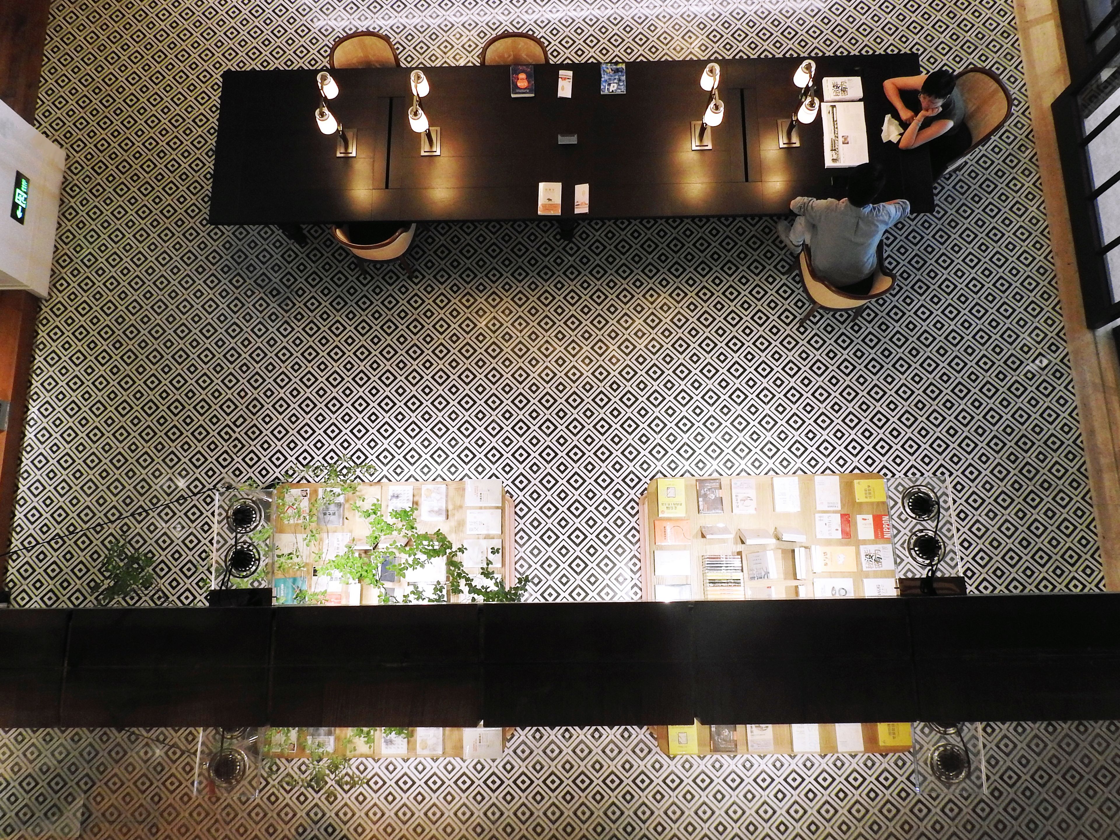 A reception desk with a patterned floor, a counter with a menu, and a view of the lobby area.