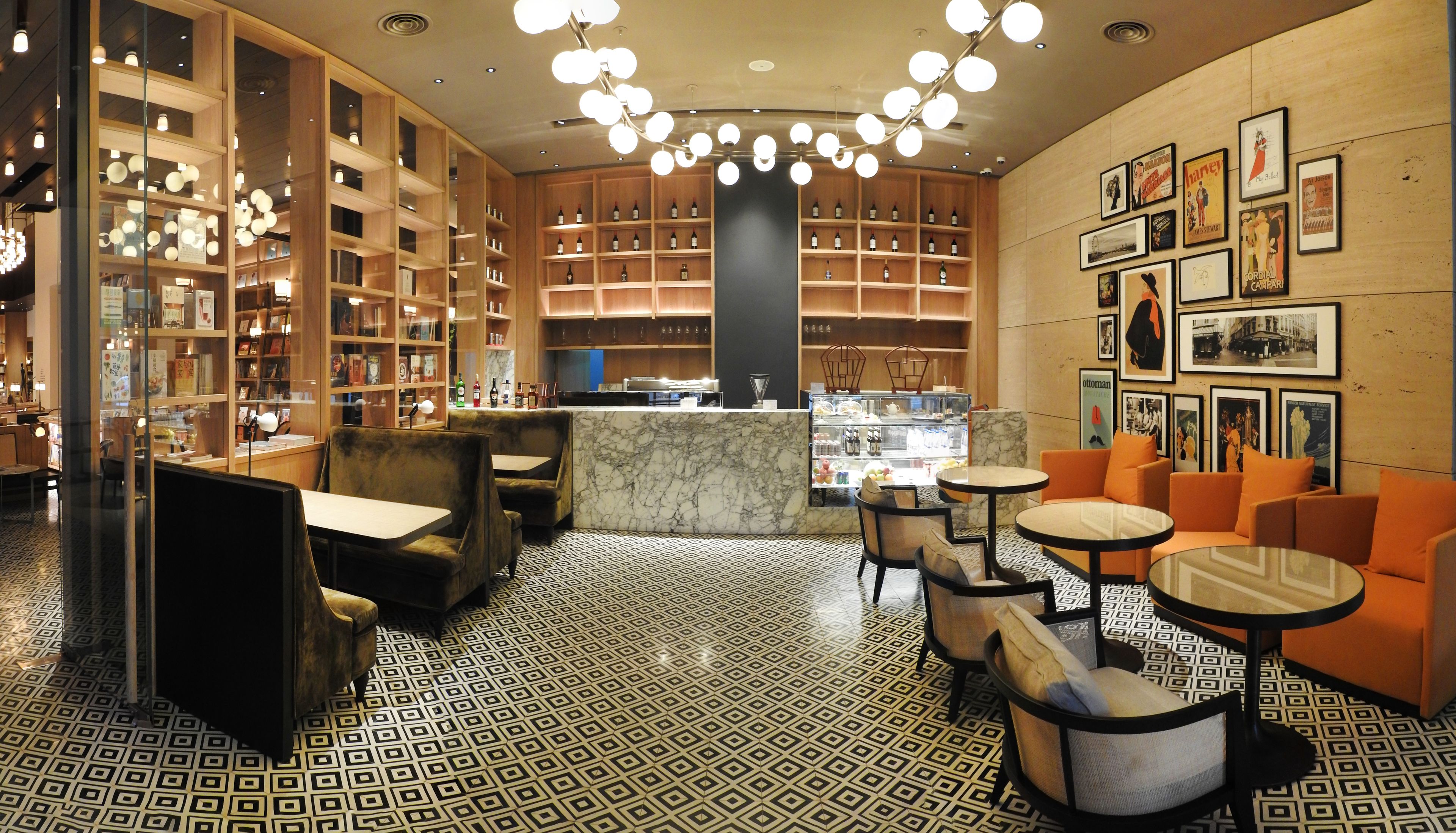 Una biblioteca con scaffali, un bancone in marmo e zone relax.