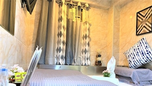 A hotel room with a bed, a bedside table, a lamp, a mirror, a window with curtains, and a wall-mounted artwork. - Super Guest House (Kowloon)