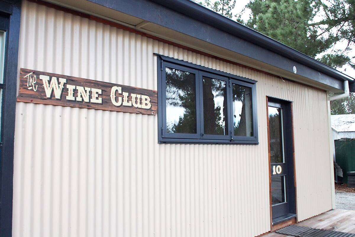 Un bâtiment sur lequel on peut lire l’inscription « Le Club du Vin » sur sa façade.