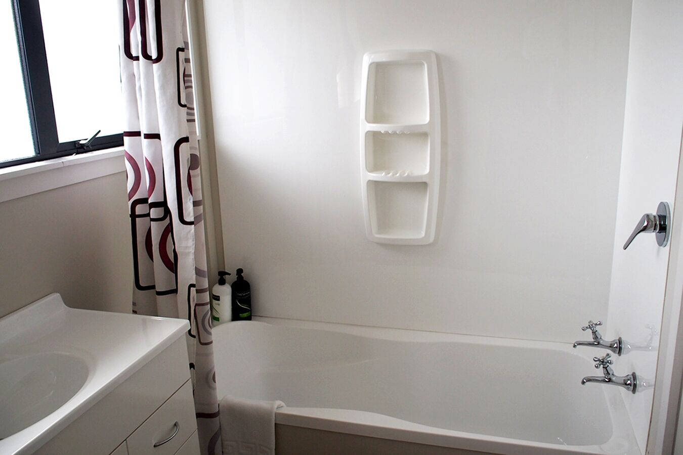 A bathroom with a bathtub, a sink, and a shower curtain.