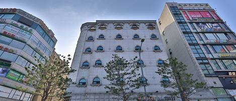 A hotel with multiple floors, large windows, and a sign for 'Grand Pen'.