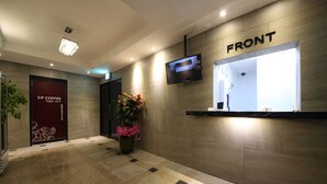 A hotel reception area with a 'SP COFFEE' sign, a potted plant, a flat-screen TV, and a 'FRONT' sign. - Hotel Sopoong (Incheon)