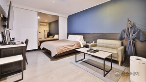 A modern hotel room with a bed, a sofa, a desk with a computer, and a television. - Hotel Sopoong (Incheon)