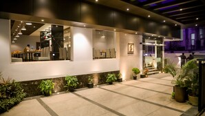 Un moderno vestíbulo de hotel con mostrador de recepción, zona de estar y una escalera que conduce a los pisos superiores.
