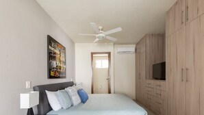 A bedroom with a bed, a nightstand, a ceiling fan, a wardrobe, and a TV. - Large apartment with pool and terrace! (Cancún)