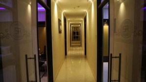 A corridor with a polished floor and a door at the end.