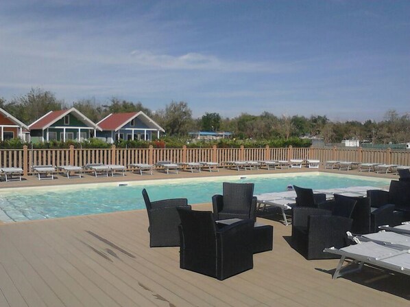 A poolside area with lounge chairs and a swimming pool.